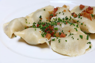 Dumplings with bacon and green chives close up