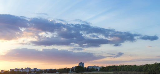 The beautiful sunset over the trees and sky gold sunset with natural sunlight against the backdrop of city houses and factories