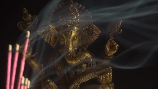 Hindu God Ganesha and smoking incense sticks