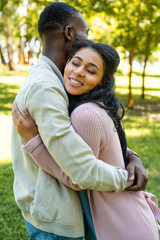 side view of african american couple hugging in park