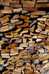 Wooden background of firewood stacked in a woodpile on a farm