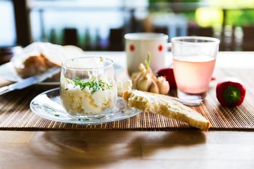 Cottage cheese in glass bowl, drink and bread.