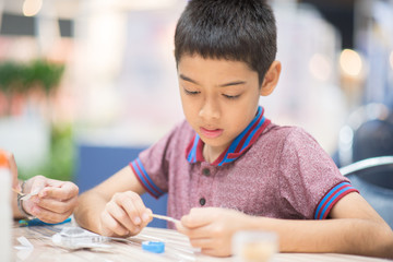 Little boy making an aircraft paper