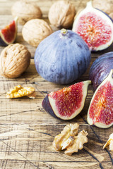 Fresh figs whole and cut with walnut kernels on a wooden old background. copy space