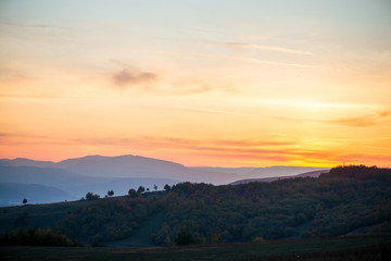 Romantic, bright and colorful sunset over a mountain range in Transilvania. Beautiful, colorful autumn background.  
