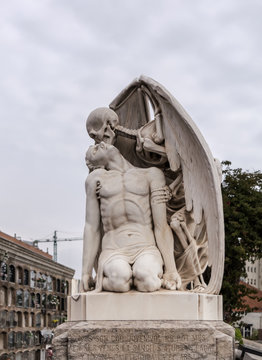 The Kiss of Death statue in Poblenou Cemetery in Barcelona. This marble sculpture depicts death, as a winged skeleton, kissing a handsome young man. The sculpture is at once romantic and horrifying.