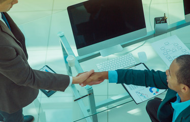 handshake between colleagues in the workplace in the office.