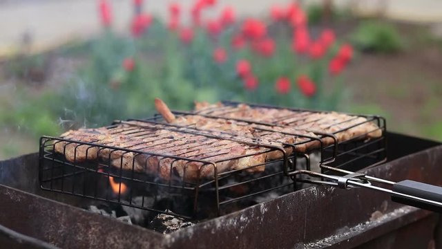 Grilled pork steaks on the grill in the garden, springtime, close up.

