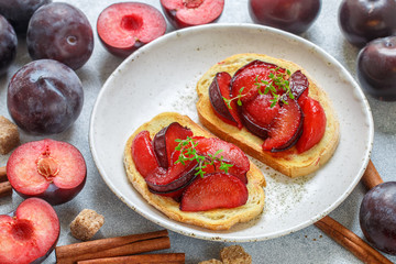 Fruit sweet bruschetta with caramel plums, cinnamon and thyme. Gourmet Breakfast
