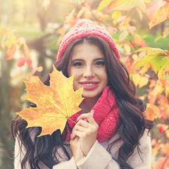 Beautiful smiling woman with yellow leaf outdoors, closeup portrait