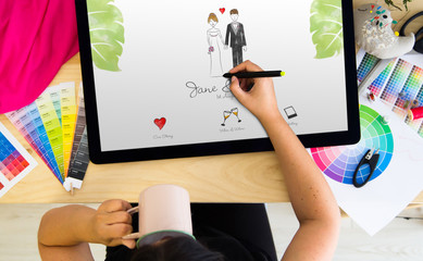 designer drawing wedding invitation on a tablet