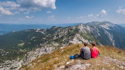 Couple sitting on the top of the Vogel mountain in the Triglav Park.