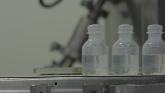 Sterilized clogged plastic bottles with medicine on the conveyor of Blow fill seal technology a manufacturing technique used to produce liquid-filled container on a medical or food industrial factory