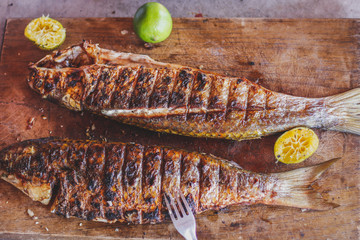 Authentic grilled  fish in a cutting board. horizontal view from above