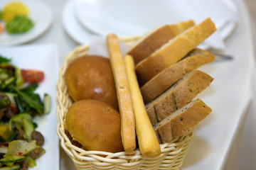 Bread in a basket on the table. The buffet food served. 