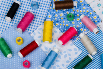 Multicolored threads, buttons on blue fabric