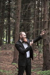 Fototapeta na wymiar confident businessman in a business suit taking a selfie in a forest.