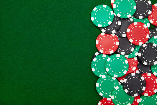 Casino chips on green poker table. Background with copy space.