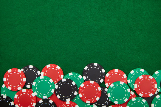 Casino chips on green poker table. Background with copy space.