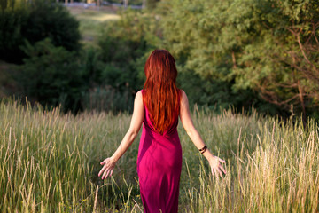  The moment of harmony. The concept of freedom.Walks through the forest alone. A slender young girl in a long dress gently touches her fingers to the grass.