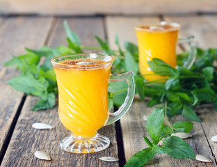 Healthy pumpkin fruit smoothie with seeds and mint leaves on table