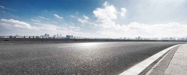 empty asphalt highway street with city skyline