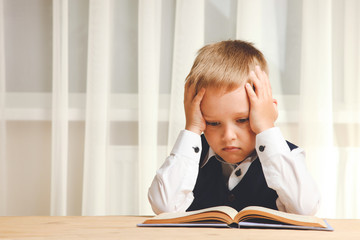 Serious schoolboy reads book