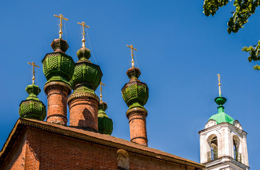Green domes of the temple with crosses against the blue sky