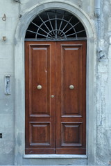 Fototapeta na wymiar porta in legno facciata palazzo antico, toscana firenze