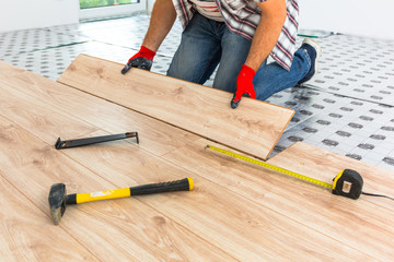Handyman installing new laminated wooden floor