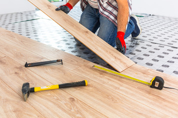 Handyman installing new laminated wooden floor