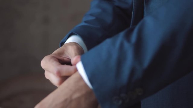 A young man fastens suit.