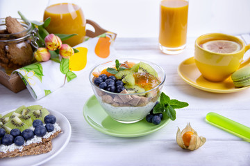 Yogurt with chia seeds, corn pads, kiwi, blueberries, physalis and mint. Healthy breakfast