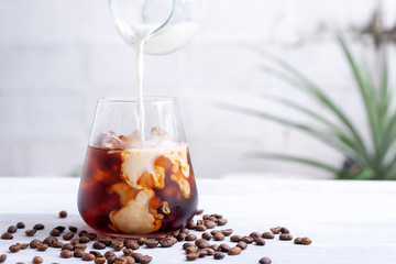 cold brew coffee with milk on white wooden table - obrazy, fototapety, plakaty