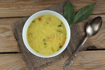 Chicken soup with a laurel leaf and a spoon for dinner