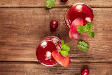 Overhead photo of vibrant red drink with berries on a rustic background