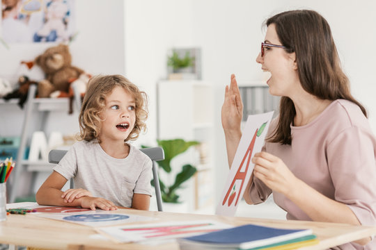 Speech therapist teaching letter a young boy in a classroom