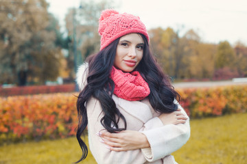 Cheerful woman with long wavy hair in autumn park outdoors