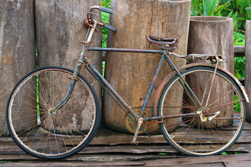 Fototapeta na wymiar An old retro antique vintage bicycle leaning against wooden fence 