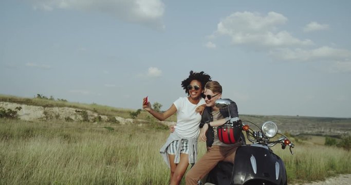 In the middle of nature couple have nice time together taking pictures sitting on their retro motorcycle. slow motions