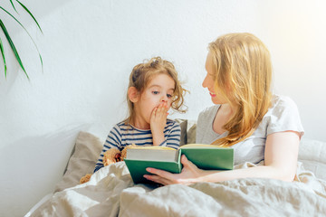 happy family mother reading to daughter in bed. wonderful world of books for children. Acquaintance...