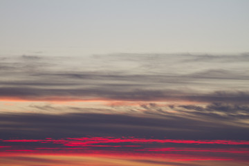 Sky clouds background. Cumulus pink red clouds in the sunset. Color clouds in the evening. Sky with a pastel colored background