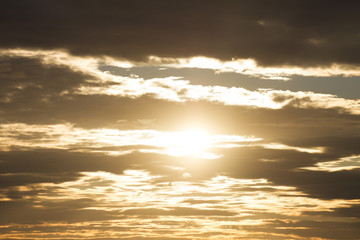 Sky clouds background. Cumulus orange clouds in the sunset. Color clouds in the evening. Sky with a dark pastel colored background