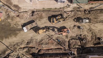Aerial construction site with machinery. Top down view of city building site.