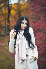 Fototapeta na wymiar Young woman in autumn coat on fall park background outdoors, portrait
