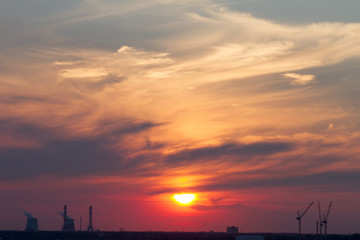 Fototapeta na wymiar Sunset over the city. CHP pipes, power station
