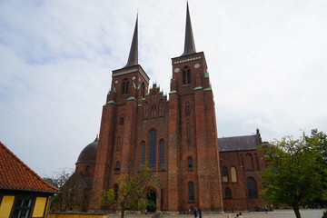 Fototapeta na wymiar Roskilde Cathedral is a cathedral of the Lutheran Church of Denmark. The first Gothic cathedral to be built of brick, it encouraged the spread of the Brick Gothic style throughout Northern Europe