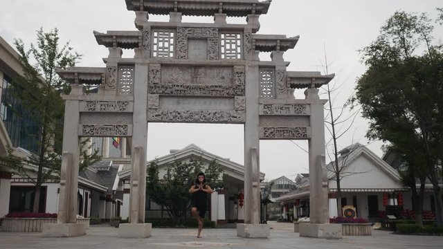 Adult man acting silly funny in monkey mask in front of ancient temple somewhere in asia