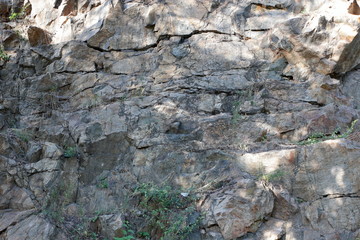 Fototapeta premium Granite rocks in the sun. Texture of granite stone. Background of natural material. Rocky rocks of ancient times