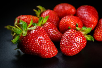 Fresh organic Strawberries on black elegant background. Selective focus